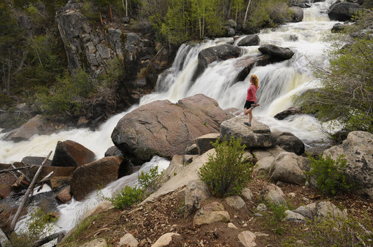 Woman trail running the Middle Fork Falls trail in Sinks Canyon. Lander, Wyoming. USA