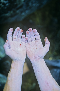 Woman realizing boulders are harder than skin, Cathedral Boulders, British Columbia, Canada.