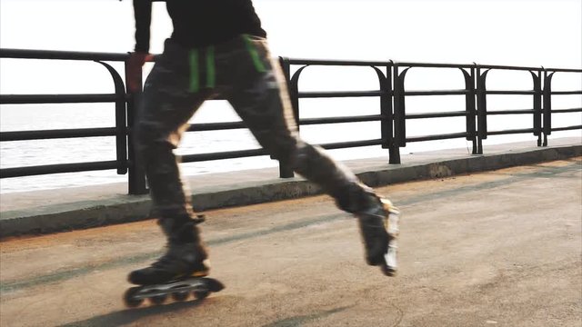 Mans legs roller skating inline close up on the asphalt sunset HD