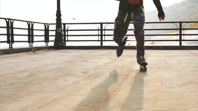 Mans legs roller skating inline close up on the asphalt sunset HD