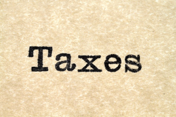 A close up image of the words "Taxes" from a typewriter