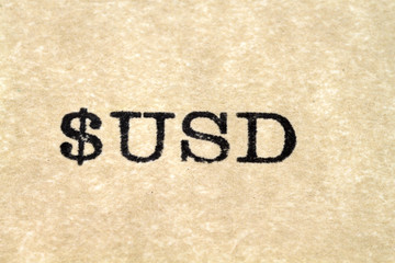 A close up image of the words "$USD" from a typewriter