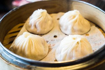 4 shrimp and pork Chinese dumplings know as Xaio Long Bao in hot bamboo tray