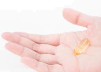 a tablet of medicine in hand on white background