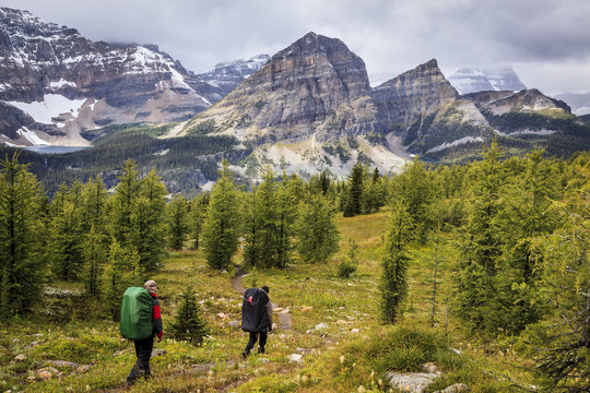 Two back packers descend the trail from Healy Pass to Egypt Lake in Banff National Park, Alberta, Canada. Model Released