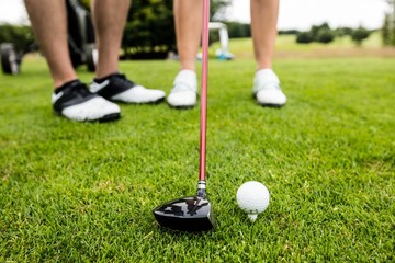 Male instructor assisting woman in learning golf