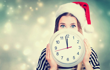 Woman holding clock showing nearly 12
