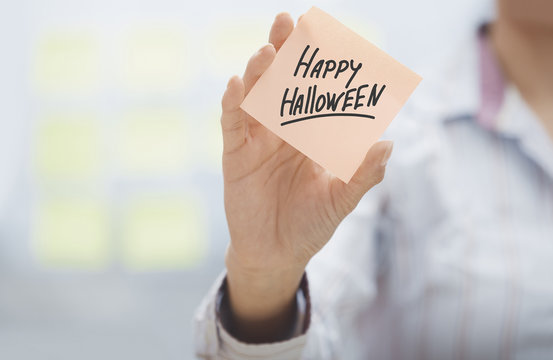 Woman holding agenda with Happy Halloween text