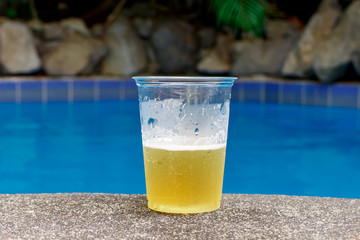 beer on plastic glass on pool