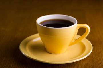Yellow coffee cup on a wooden table