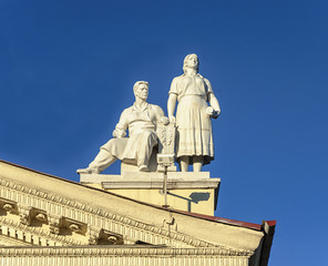 Obraz premium Sculpture of man and women on the roof of Trade Union Palace in