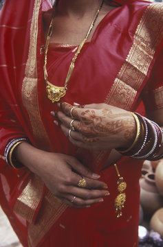 India, Rajsatan, Jaipur woman's hand with henna tattoo, red sari and gold jewellry