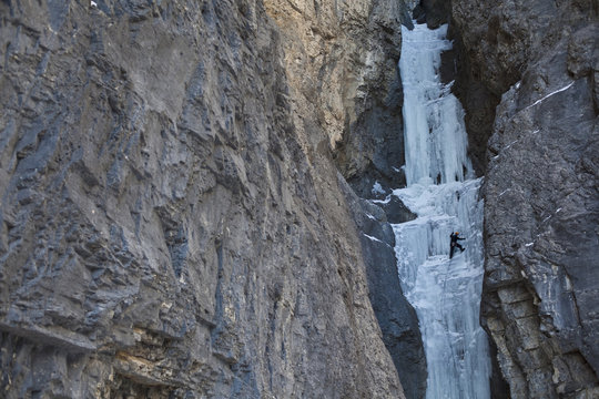 A middle aged man climbc Aquarius WI4, in the beautiful Ghost River Valley, Alberta, Canada