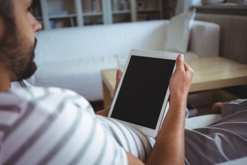 Man using digital tablet in living room