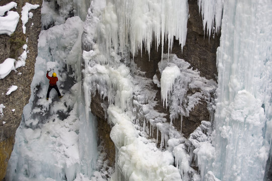 A male ice clmber tackles some steep ice in Johnstone  Canyon, Banff National Park, AB