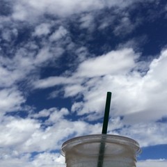 Cup of coffee on a beautiful blue sky with white clouds 