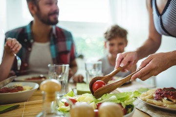Woman serving meal to her family