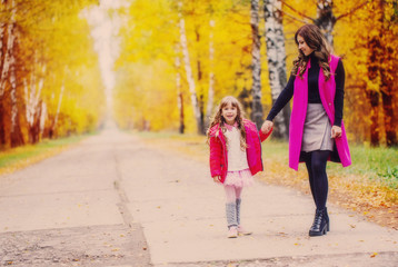 Mother and her little daughter at beautiful autumn park