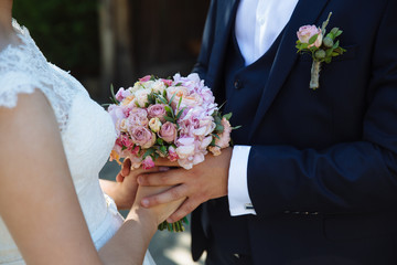 Wedding bouquet in marriage couple hands