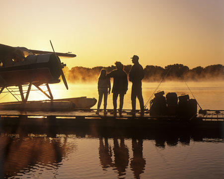 family on float plane dock, along Red River, Manitoba, Canada