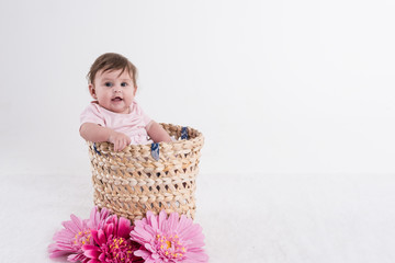 chillendes Baby in Korb mit rosa Blumen