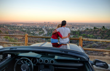 Couple watching sunset from popular view point in Los Angeles