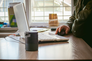 Fototapeta premium adult man with a mustache and glasses, working at a computer, holding a mouse in their hands.