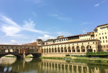 Fototapeta na wymiar Florence, Italia - July 25th : view of the famous Ponte Vecchio in Florence during summer with boats on the river. 