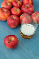 Ripe red apples with a glass of cider
