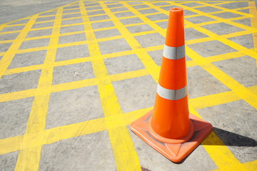 Traffic cone in the road yellow stripes