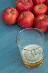 Ripe red apples with a glass of cider