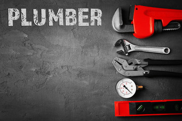 Plumbing concept. Plumber tools on concrete structure background