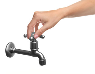 Female hand turning tap isolated on white. Water saving concept