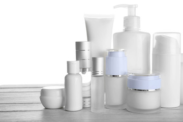 Different cosmetic bottles on table on white background