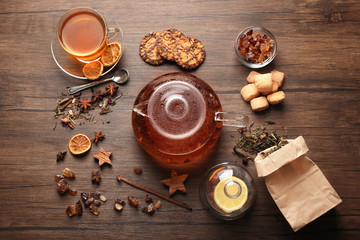 Ingredients for tea drinking on wooden background, flat lay