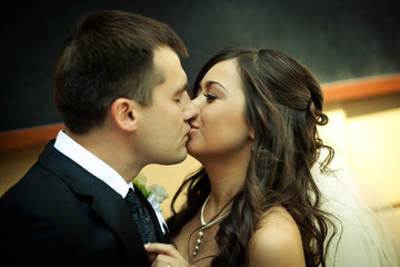 Groom kisses tender bride 