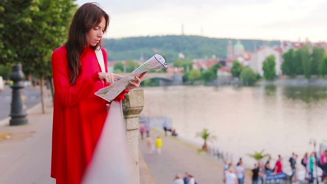 Happy young woman with a city map in Europe. Travel tourist woman with map in Prague outdoors during holidays in Europe.