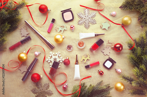 “Colorful makeup cosmetic with Christmas decoration on golden textile
