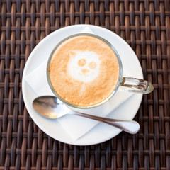 Cup of hot latte art coffee on wicker wooden table.