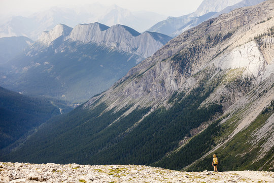 A young woman hikes the Sulphur Skyline Trail with a view of Ashlar Ridge. Miette Hotsprings, Jasper National Park, Alberta, Canada.