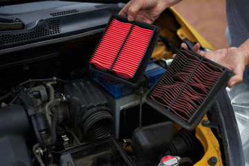 Comparison new and used air filter for car with engine bachground.