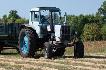 Old tractor in summer on field.