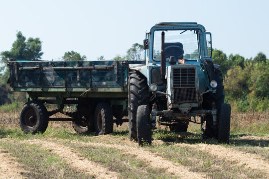 Old tractor in summer on field.