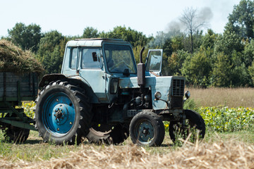 Old tractor in summer on field.