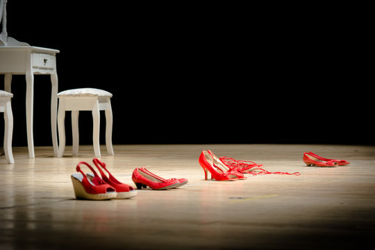 Scarpe rosse su un palco, simbolo della violenza sulle donne