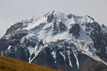Fototapeta na wymiar Rocky slope of mountain peaks, glaciers, snowfields