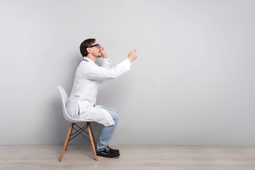 Concentrated doctor sitting on a chair with stethoscope