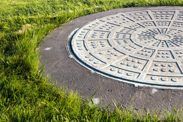 Closeup of a manhole and green grass