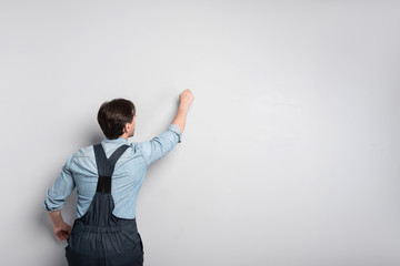 senior concentrated man writing on the wall.