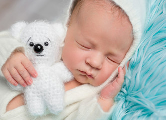 lovely sleeping newborn boy with little toy, close up